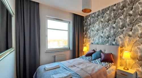 1 dormitorio con cama y ventana en Copernicus Park Centrum, en Słupsk