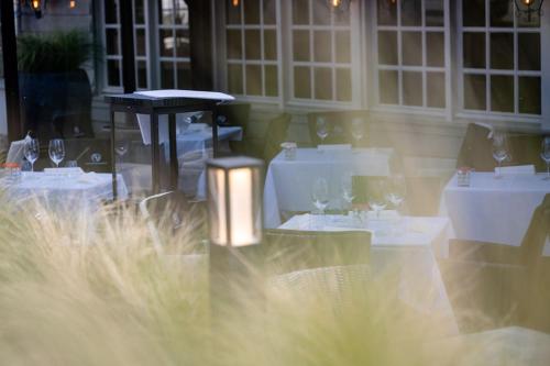 a restaurant with white tables and chairs with wine glasses at Boutique Hotel Slenaker Vallei - Buitengewoongenieten in Slenaken