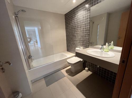 uma casa de banho com uma banheira, um WC e um lavatório. em Beach & Culture Barcelona Port Forum Penthouse Apartment em Barcelona