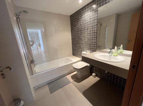 a bathroom with a tub and a toilet and a sink at Beach & Culture Barcelona Port Forum Penthouse Apartment in Sant Adria de Besos