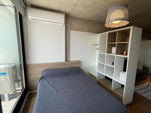 Dormitorio pequeño con cama y estante en Cute studio in downtown Bs As 5G 3 pax en Buenos Aires