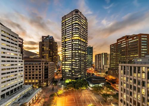 a city skyline with tall buildings at dusk at One Thibault Luxury Apartments in Cape Town