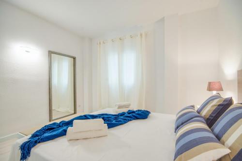 ポルト・ダルクディアにあるIdeal Property Mallorca - Canet Beachの白いベッド(青いシーツ、鏡付)