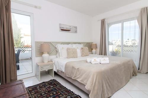 een witte slaapkamer met een bed met handdoeken erop bij Apartamento Luna - Golf View By Dalma Portuguesa in Branqueira