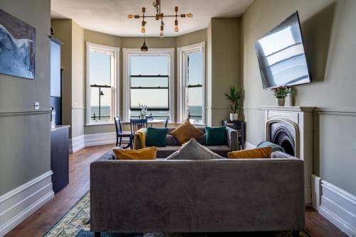 a living room with a couch and a tv at Beachfront Bolthole with Luxury, Style and Spectacular Sea Views in Herne Bay