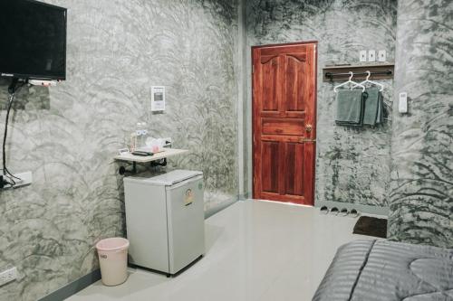 a bathroom with a small refrigerator and a red door at YOJI House and Cafe in Ban Wiang