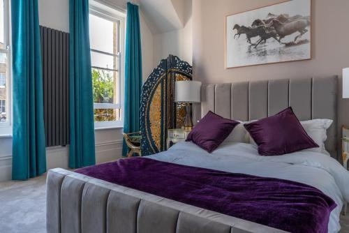 a bedroom with a large bed with purple sheets at Beachfront Luxury Home with Spectacular Sea Views in Herne Bay