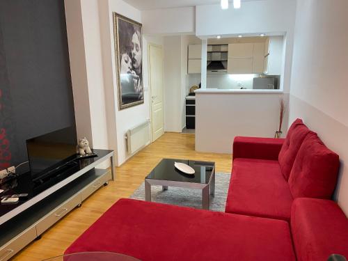 un salon avec un canapé rouge et une table dans l'établissement Apartment Alex, à Ohrid