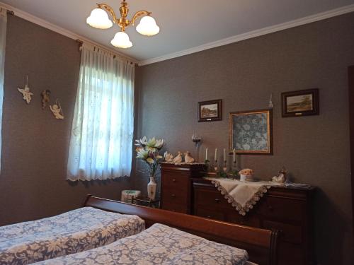 a bedroom with two beds and a dresser and a window at Harmath Vendégház Balatonszárszó in Balatonszárszó