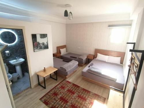 een kleine kamer met 2 bedden en een wastafel bij Champollion Hostel in Caïro