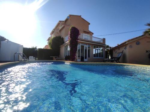 a large swimming pool in front of a house at Villa ROSA in Els Poblets