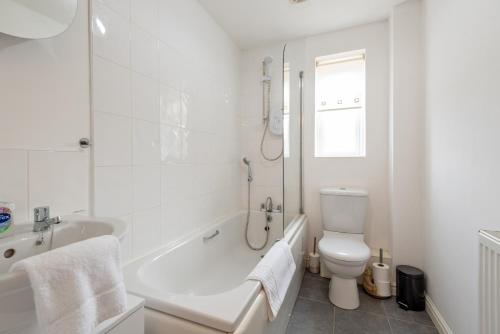 a white bathroom with a tub and a toilet at Durham Gate View in Spennymoor