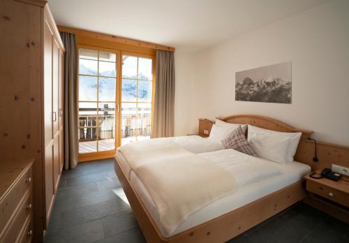 a bedroom with a large bed and a large window at AlpinLodges Kühtai in Kühtai