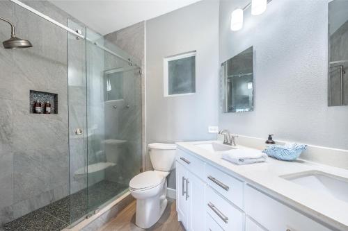 a bathroom with a shower and a toilet and a sink at Salty Adventures at Twin Dolphins in Playa Flamingo