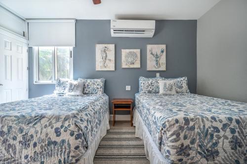 - 2 lits dans une chambre aux murs bleus dans l'établissement Salty Adventures at Twin Dolphins, à Playa Flamingo