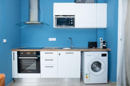 a kitchen with a washing machine and a blue wall at Charme Alizea Skyline wifi-terrasse in Rémire-Camp