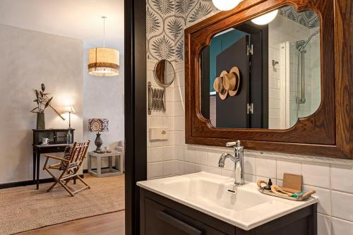 La salle de bains est pourvue d'un lavabo et d'un miroir. dans l'établissement Hospedium Hotel La Farm, à Real Sitio de San Ildefonso