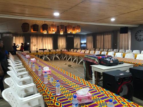a room with a long table with white chairs and tables sidx sidx sidx at Tropicana Beach & Resort in Elwa