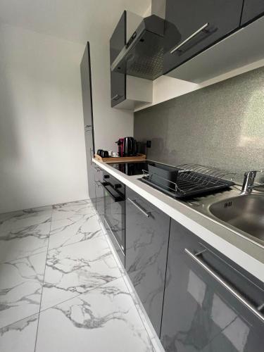 une cuisine avec un évier et un plan de travail dans l'établissement Suite cinéma et jacuzzi privé, à Melun