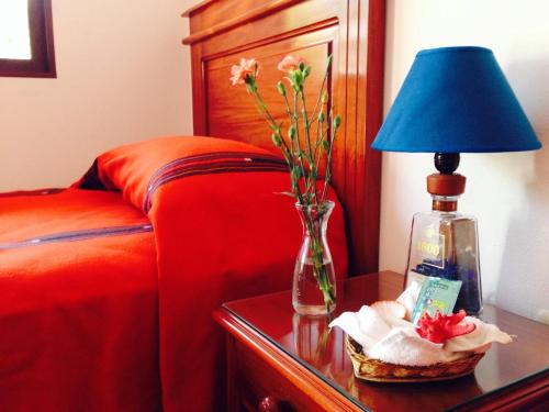 1 dormitorio con 1 cama y 1 mesa con lámpara en Matalbatz Hotel, en Cobán
