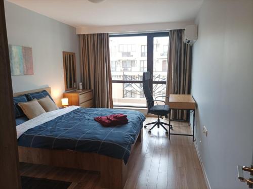 a bedroom with a bed and a desk and a window at One Bedroom Apartment 37- Trakia 54 А in Plovdiv