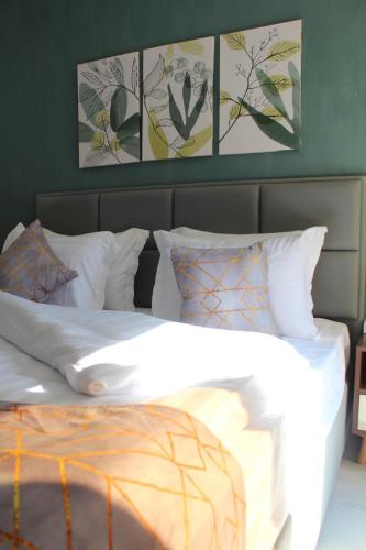 een bed met witte lakens en kussens in een slaapkamer bij Jasmine Pyramids Hotel in Caïro