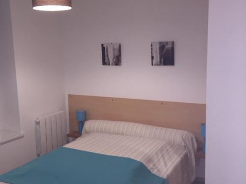 ル・モンドールにあるAppartement Mont-Dore, 4 pièces, 6 personnes - FR-1-415-24のベッドルーム1室(ベッド1台付)が備わります。壁に2枚の写真が飾られています。