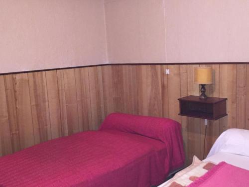 ル・モンドールにあるAppartement Mont-Dore, 2 pièces, 3 personnes - FR-1-415-26のピンクのシーツとランプが備わるベッド2台付きの部屋