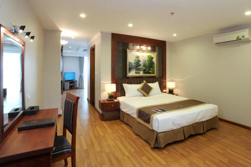 a hotel room with a bed and a desk and a desk at Gallant Hotel in Hanoi