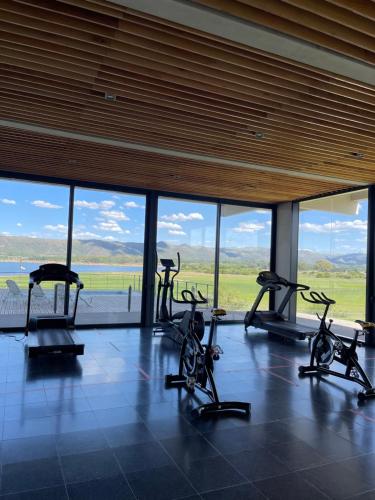 un gimnasio con bicicletas cardiovasculares frente a una gran ventana en Departamento Country Puerto del Águila- Lago los Molinos in 