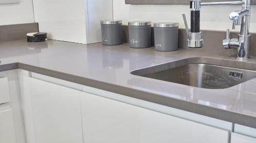 a kitchen counter with a sink and trash cans at The Pink House in Durham