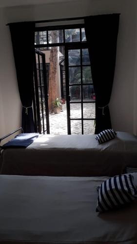 a bed in a room with a window and a bed sidx sidx sidx at LA CASITA in Buenos Aires