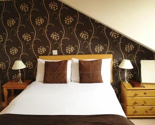 a bedroom with a white bed and a black wall at the noel @ whitwell in Oakham