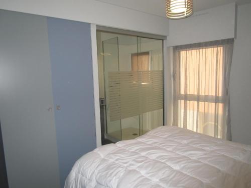 ein weißes Schlafzimmer mit einem Bett und einem Fenster in der Unterkunft Appartement Les Sables-d'Olonne, 2 pièces, 4 personnes - FR-1-197-367 in Les Sables-dʼOlonne