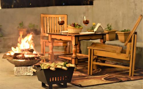 une terrasse avec un foyer extérieur, une table et une chaise dans l'établissement Spire View, à Manali