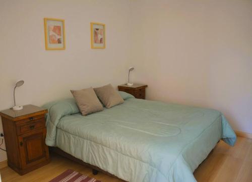 1 dormitorio con 1 cama y mesita de noche con 2 lámparas en Hermoso departamento en G. Cruz en Godoy Cruz