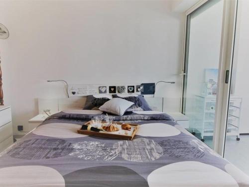 - un grand lit avec un plateau de nourriture dans l'établissement Arcachon centre T3 refait à neuf avec parking sécurisé, accès direct plage - FR-1-420-60, à Arcachon
