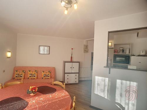 une chambre avec un lit, un canapé et un miroir dans l'établissement Appartement F2 lumineux avec balcon, proche centre et Thermes, animaux acceptés, wifi gratuit - FR-1-451-21, à Lamalou-les-Bains
