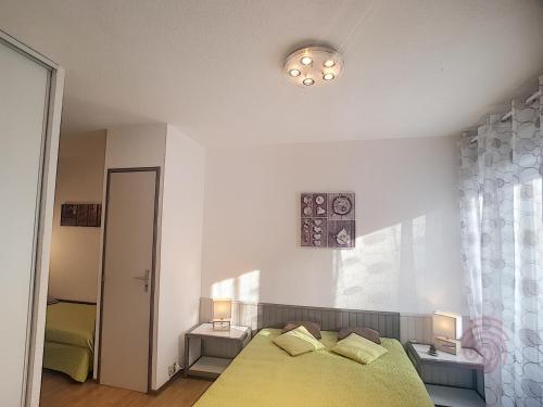 une chambre avec un lit jaune et une fenêtre dans l'établissement Appartement F2 lumineux avec balcon, proche centre et Thermes, animaux acceptés, wifi gratuit - FR-1-451-21, à Lamalou-les-Bains