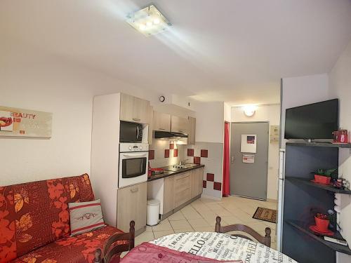 un salon avec un canapé et une cuisine dans l'établissement Bel F2 climatisé à 400m du centre, WiFi, animaux acceptés - FR-1-451-22, à Lamalou-les-Bains