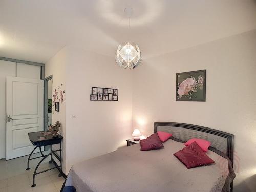 ラマルー・レ・バンにあるAppartement Lamalou-les-Bains, 2 pièces, 2 personnes - FR-1-451-22のベッドルーム1室(赤い枕2つ付きのベッド1台付)