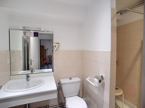 une salle de bain avec toilettes, lavabo et miroir dans l'établissement Appartement F2 climatisé avec terrasse, proche thermes et centre-ville, animaux acceptés, à Lamalou - FR-1-451-4, à Lamalou-les-Bains