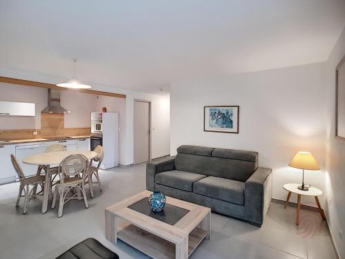 un salon avec un canapé et une table dans l'établissement Appartement F2 climatisé avec terrasse, proche thermes et centre-ville, animaux acceptés, à Lamalou - FR-1-451-4, à Lamalou-les-Bains