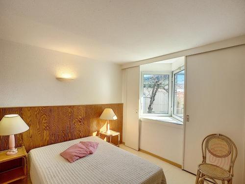 um quarto com uma cama e uma janela em Appartement Lamalou-les-Bains, 2 pièces, 2 personnes - FR-1-451-23 em Lamalou-les-Bains