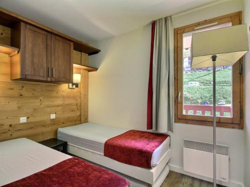 une chambre avec deux lits et une fenêtre dans l'établissement Appartement cosy sur les pistes avec balcon et WiFi - FR-1-455-1, à Belle Plagne
