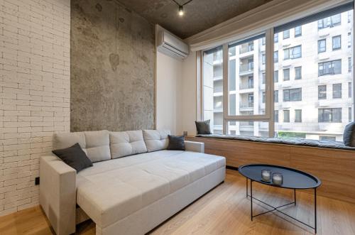 a living room with a couch and a large window at 3131Designer apartments in the residential complex "Yaroslaviv Grad" in Kyiv