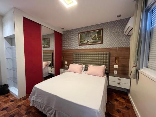 1 dormitorio con 1 cama con 2 almohadas rosas en Copa Paradiso, en Río de Janeiro