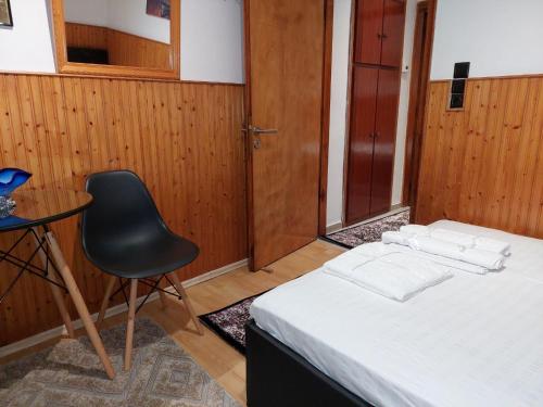 a bedroom with a bed and a chair and a table at ΔΙΑΜΕΡΙΣΜΑ ΧΩΡΗΤΙΚΟΤΗΤΑΣ ΜΕΧΡΙ 4 ΑΤΟΜΩΝ ΚΕΝΤΡΙΚΑ! in Metsovo