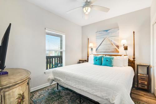a bedroom with a large white bed with blue pillows at Purple Paradise in Freeport