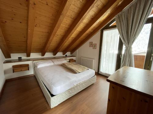 um quarto com uma cama e um tecto de madeira em Condominio Gaiolin em Giustino